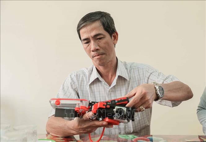 Ông Huỳnh Ngọc Dũng, Giám đốc Ban Quản lý Khu bảo tồn biển Lý Sơn, lắp đặt hệ thống, kiểm tra thiết bị ghi nhận hình ảnh dưới nước trước khi cùng các chuyên gia thực hiện Phototransect dưới đáy biển. (Ảnh: Phan Phương/TTXVN)
